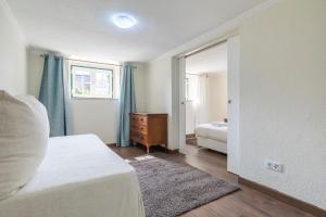 a bedroom with a white bed and a mirror at Kochab Sintra by LovelyStay in Sintra