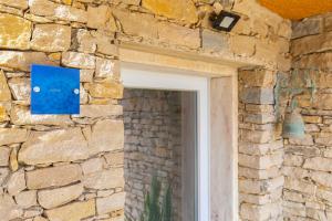 a window in a stone wall with a blue sign on it at Kochab Sintra by LovelyStay in Sintra