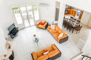 einen Blick über ein Wohnzimmer mit orangefarbenen Möbeln in der Unterkunft Villa Deja Blue by Ezoria Villas in Coral Bay