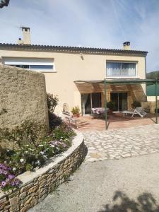 a house with a stone wall and a patio at Villamijo in Le Beausset