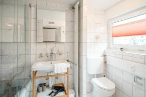 a white bathroom with a sink and a toilet at Hinterzarten Freiburgerstraße by Kuckucksnester in Hinterzarten +12 photos