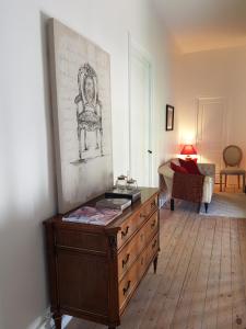 a room with a dresser with a drawing on the wall at Domaine et Manoir du Picaud in Monestier +26 photos