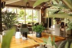 un comedor con una mesa de madera y plantas en EuroParcs Spaarnwoude en Halfweg