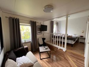 a living room with a crib and a bedroom at Saras Hotel FD Amadeus in Ängelholm