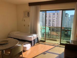 a hotel room with a bed and a large window at Exclusividade e conforto na savassi in Belo Horizonte +18 photos