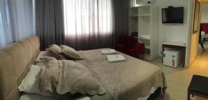 a bedroom with a bed with two towels on it at Vila Alaide Praia Hotel in Barra Velha