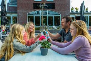 un grupo de personas sentadas en una mesa con una copa de vino en EuroParcs Spaarnwoude en Halfweg
