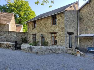 une ancienne maison en pierre avec un mur en pierre dans l'établissement Les quatre vents, à Ars