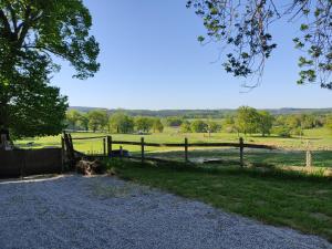 a wooden fence in a field next to a pasture at Les quatre vents in Ars +16 photos