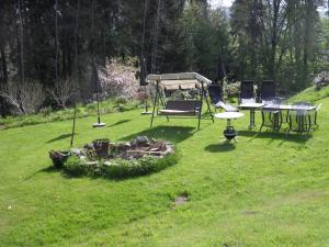 een groep tafels en stoelen in een grasveld bij Tiny House in Thermalbad Wiesenbad