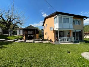 ein Haus mit grünem Rasen davor in der Unterkunft Pool Villa Sarajevo in Sarajevo