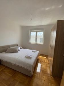 Un dormitorio blanco con una cama y una ventana. en Apartman Sunny Day, en Trebinje