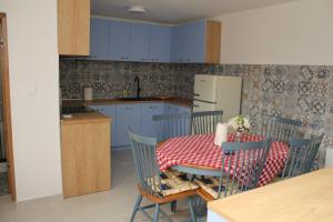 cocina con mesa y sillas y cocina con armarios azules en COUNTRY HOUSE ERDUT, en Erdut