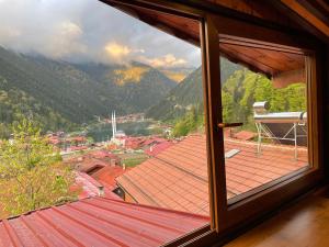 a window with a view of a town and mountains at Falay pansiyon in Uzungol