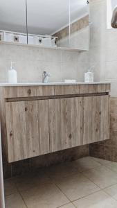 bagno con bancone in legno e lavandino di Casa di kampos ad Adelianos Kampos