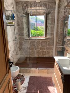 a bathroom with a shower and a toilet and a window at Kazerma Apartment in Perast +44 photos