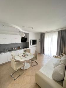 a white living room with a table and a kitchen at Apartments Tony in Biograd na Moru