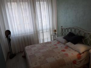 een slaapkamer met een bed en een raam met gordijnen bij Appartamento Mamma Sandra, incantevole tre posti più uno in Florence