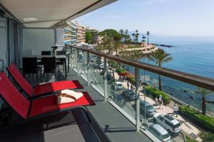 una silla roja en un balcón con vistas al océano en Royal Antibes - Luxury Hotel, Résidence, Beach & Spa, en Antibes