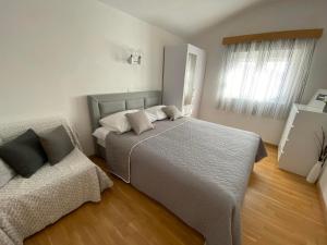 a bedroom with a large bed and a window at Apartmani Milkovic in Tučepi