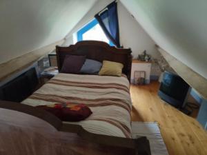 a bedroom with a large bed in a attic at La Maison Bleue de Husseau Ancienne ferme semi-troglodytique 18e siècle in Montlouis-sur-Loire