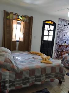 1 dormitorio con cama, ventana y puerta en Suites Mar Azul Prainha, en Arraial do Cabo