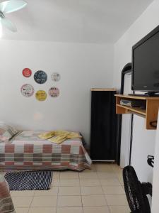 a room with a bed and plates on the wall at Suites Mar Azul Prainha in Arraial do Cabo +37 photos