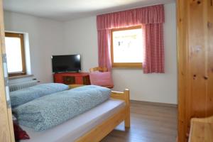 1 dormitorio con 2 camas, ventana y TV en Goldiger Hirsch en Immenstadt im Allgäu