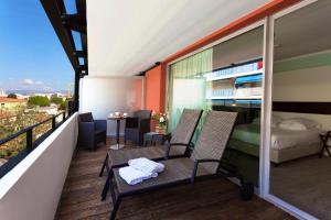 a balcony with two chairs and a bed and a table at Royal Antibes - Luxury Hotel, Résidence, Beach & Spa in Antibes