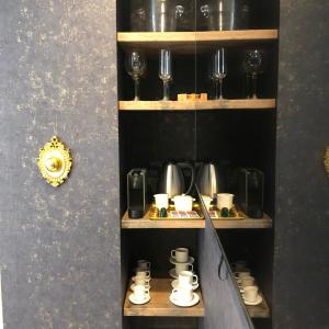 un estante con tazas y copas de vino. en Marqués Petit Premium, en Denia