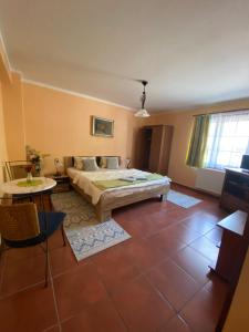 a bedroom with a bed and a table and a window at Penzion Albatros in Český Krumlov