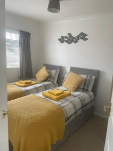 two beds in a room with yellow sheets and pillows at Chalet Bonair Spacious comfortable 2 Bedroom Chalet sleeping 4 Dartmouth in Dartmouth