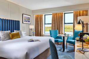 Westport Coast Hotel في ويستبورت: غرفة فندقية بسرير وطاولة وكراسي