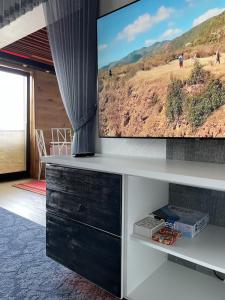 a living room with a flat screen tv on a wall at Guest House Bermuuda Family Apartment in Paide