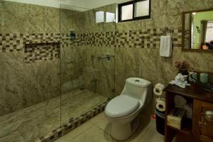 a bathroom with a toilet and a glass shower at Casa Clusia in Monteverde Costa Rica