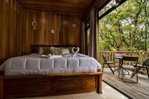 Schlafzimmer mit einem Bett auf einer Holzterrasse in der Unterkunft Casa Clusia in Monteverde Costa Rica