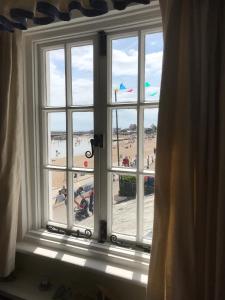 ein Fenster mit Blick auf den Strand von einem Zimmer in der Unterkunft Dolphin Cottage Lyme Regis in Lyme Regis + 15 Fotos