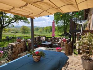 eine Terrasse mit einem blauen Tisch und einem Sonnenschirm in der Unterkunft Les quatre vents in Ars
