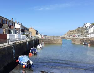 a group of boats are docked in a river at Inner Harbour Cottage in Portreath +17 photos