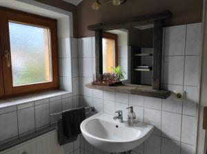 a bathroom with a sink and a mirror at Ferienwohnung Landhaus zum Sonnenschein in Marquartstein +12 photos