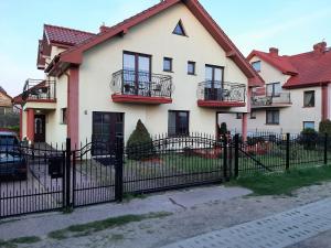 duży biały dom z czarnym płotem w obiekcie Villa na pokladzie we Władysławowie