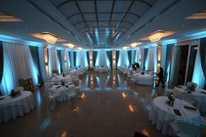 a banquet hall with white tables and people in it at Hotel Villa Pascucci in Durrës