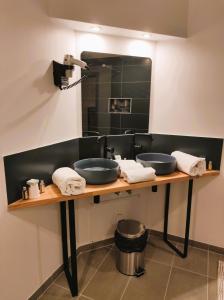 a bathroom with two sinks and a mirror at Modern'Hotel in Valenciennes