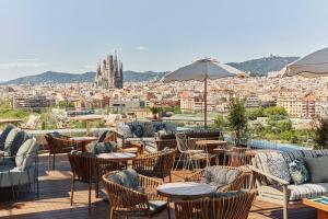 a patio with tables and chairs and a view of a city at The Hoxton, Poblenou in Barcelona
