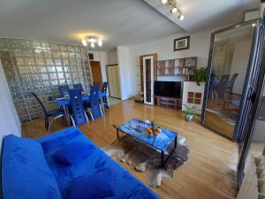 salon z niebieską kanapą i stołem w obiekcie Iva apartman w Puli