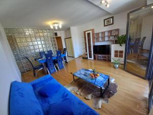 salon z niebieską kanapą i stołem w obiekcie Iva apartman w Puli