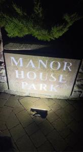 a sign that says moor house park with a gun on the ground at Flosh Caravan, Manor House Park in Mawbray