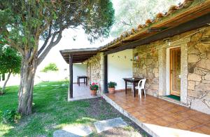 un patio di una casa con tavolo e albero di Turismo Rurale CUDACCIOLU a Arzachena