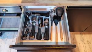 a drawer filled with utensils in a kitchen at Apartament Złote Żdżadło Nikiszowiec in Katowice