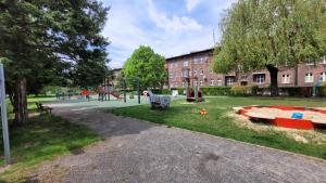 a park with a playground and a building and a building at Apartament Złote Żdżadło Nikiszowiec in Katowice